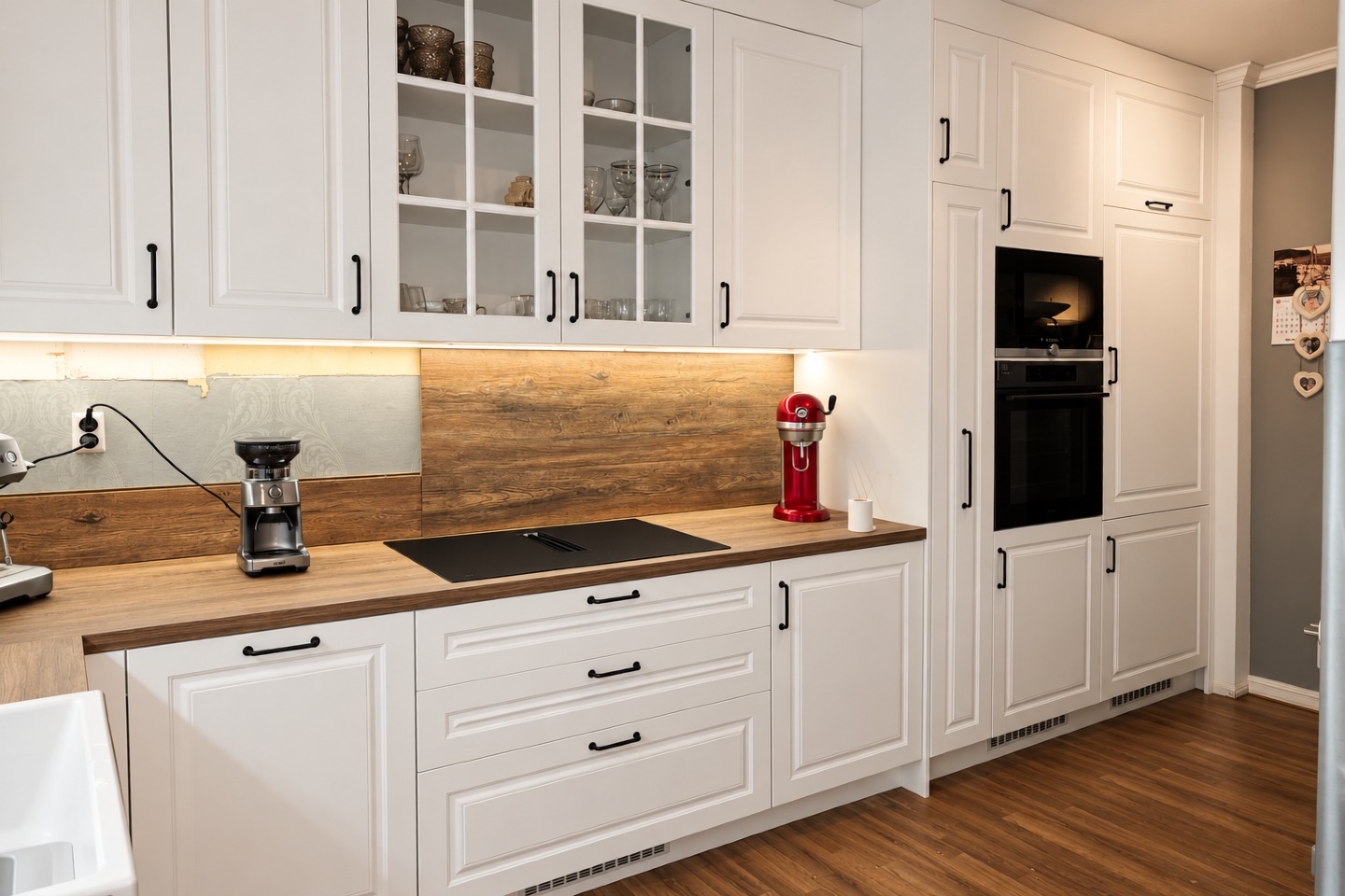 White Zoré Home kitchen with glass cabinet doors and a wood worktop